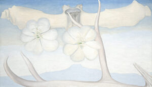 Large horizontal painting of blue and grey tones. Along the bottom in the foreground lies a bleached antler with arms reaching upward towards the sky. Floating along the top spanning the length of the canvas is a vertebral bone. Superimposed over this in the middle are two white flowers, hovering just above a blue silhouette of the Pedernal.