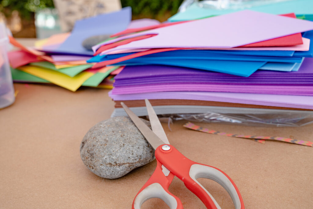 Close-up photo of art supplies including foam, scissors and a rock