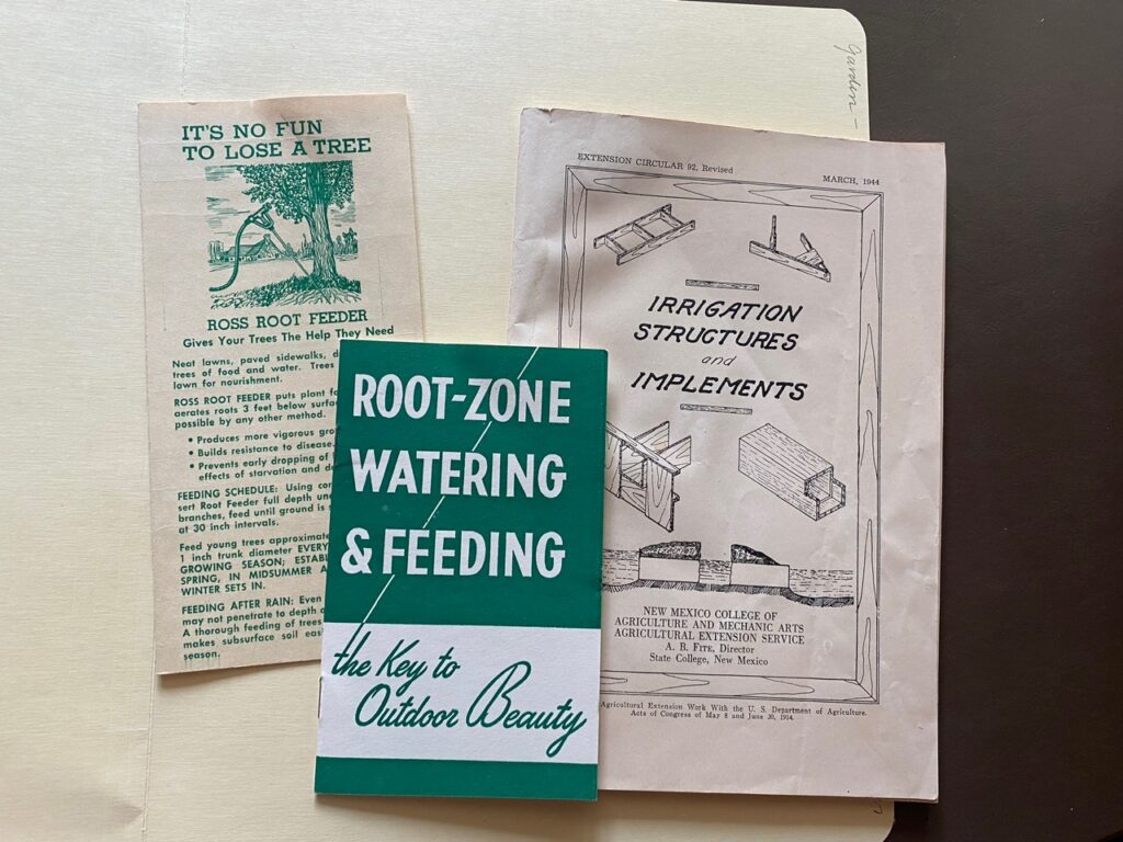 Three pamphlets on irrigation and watering trees laying in an open folder.