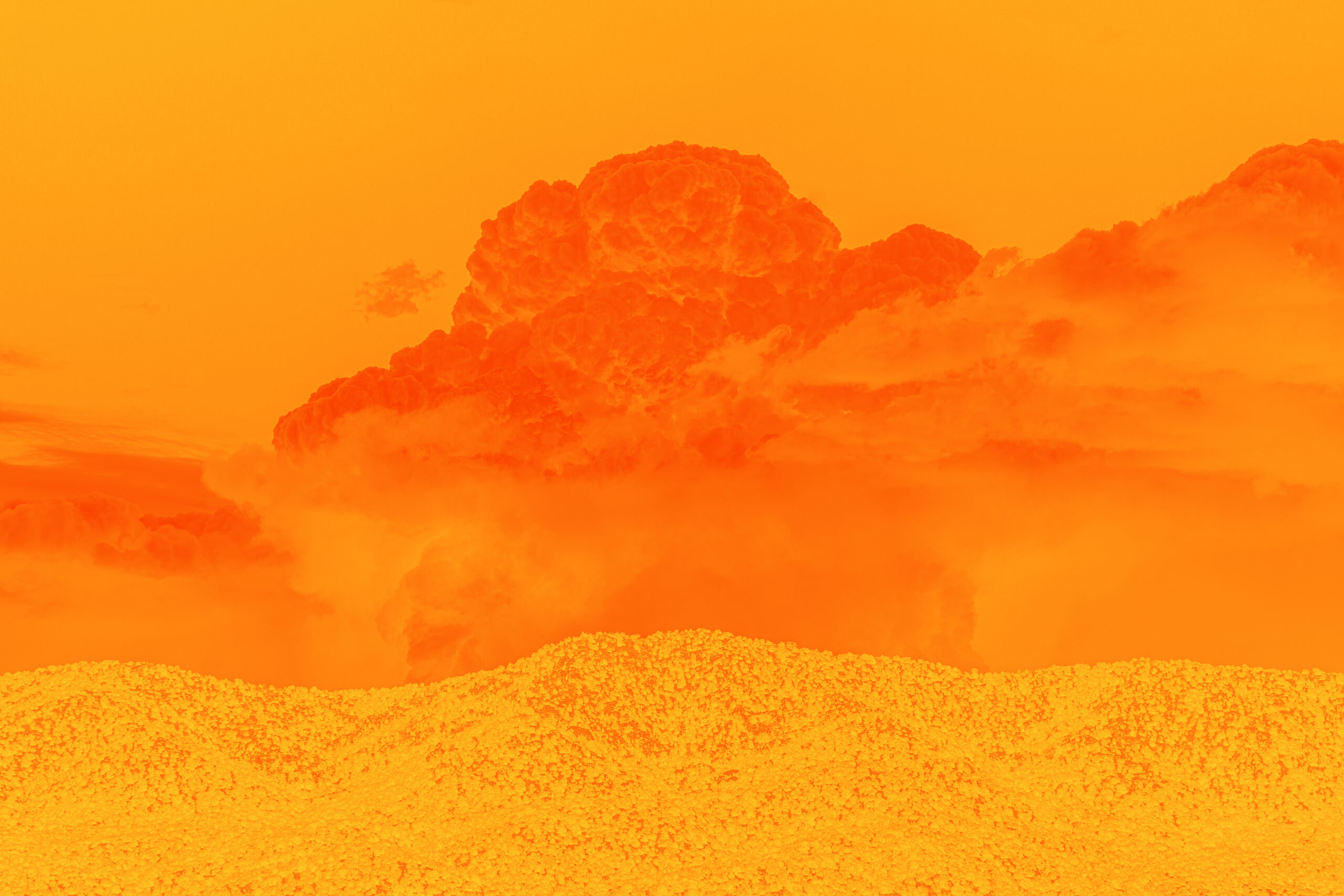 Deep dark orange clouds above the light hills of a desert landscape. The sky behind the cloud is orange and the entire canvas is bathed in orange.