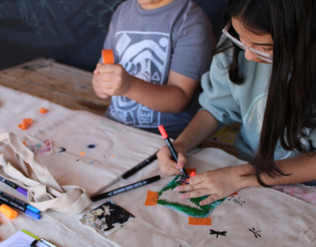 Photograph of two young children using pencils in a creative project.