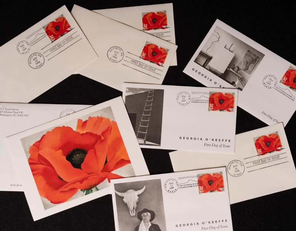 A collection of envelopes and cards with stamps featuring a huge orangish-red poppy with a black center stretches across the landscape-oriented composition. Its green stem is just visible at the bottom of the canvas. The flower contrasts with a plain white background.