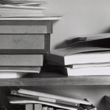A close up of a messy library shelf in black and white.