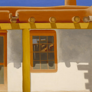 Yellowish brown support beams hold up a brown adobe patio. The patio extends from the white walls of a house, which features a window and screen door. Wooden support beams known as vigas protrude from the house's roof. A chimney emerging from the roof extends upward into a band of bright blue sky overhead.